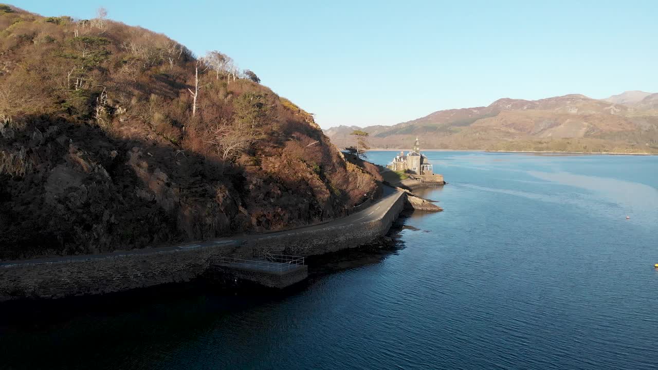 Barmouth河口的一个风景aerial backward footage with the Clock House, majestic mountain and blue water under A beautiful blue sky视频下载