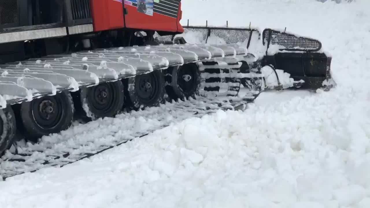 雪地车履带的特写，在雪山滑雪场工作的雪地车。除雪技术人员视频购买