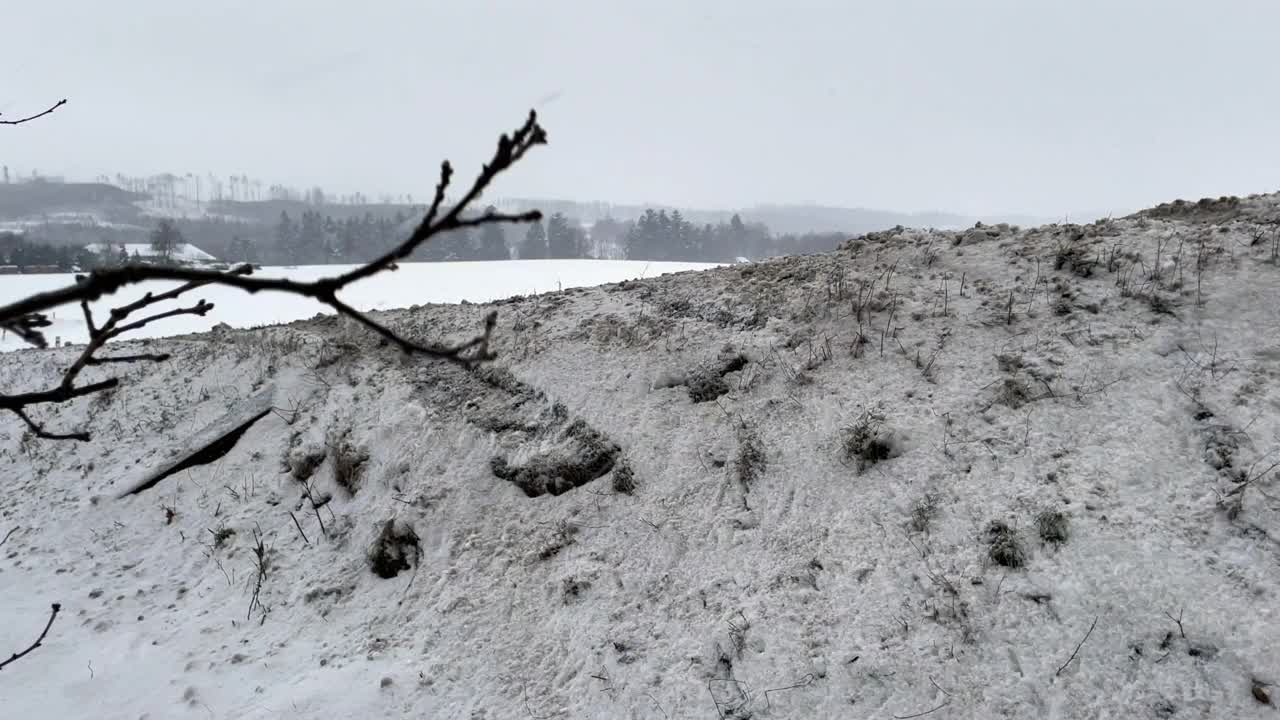 只见路边有一个高高的雪堆，然后一辆行驶的汽车又回到了下雪的路边视频下载