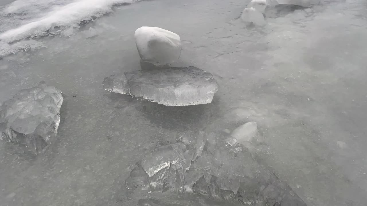 池塘中有一个冰洞，周围有冰雪浮冰，从左到右都可以看到视频下载