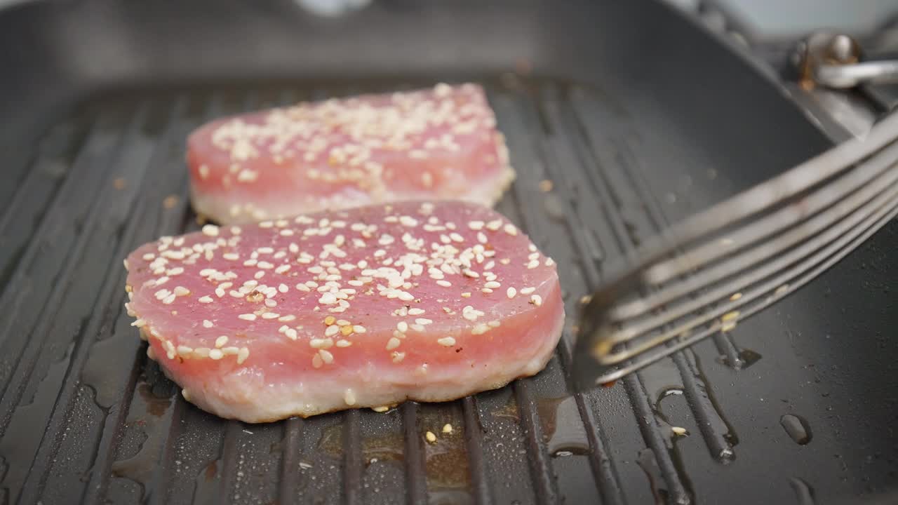 在烤盘上翻一片黄鳍金枪鱼牛排。视频下载