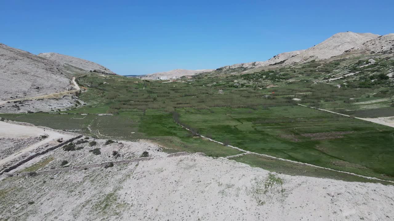 无人机在空中飞行。田野和山景从顶部和蓝色的水在背景视频下载