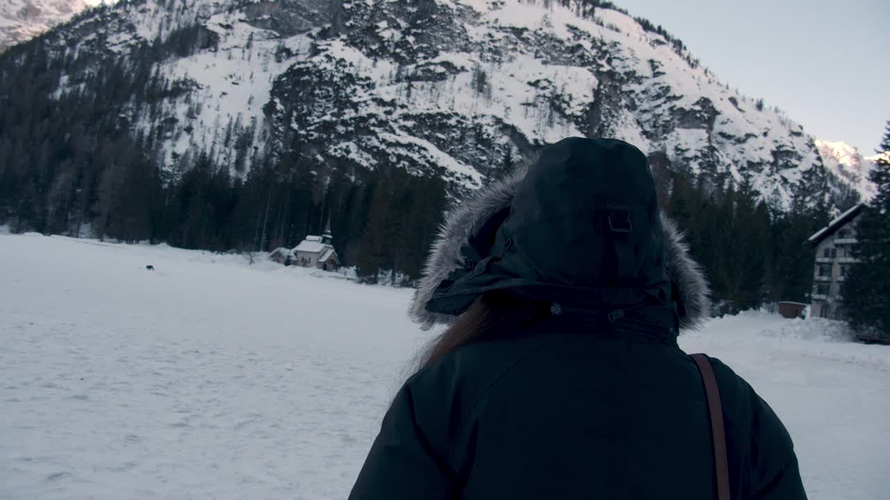 一个女孩在雪地上行走的背影。视频素材