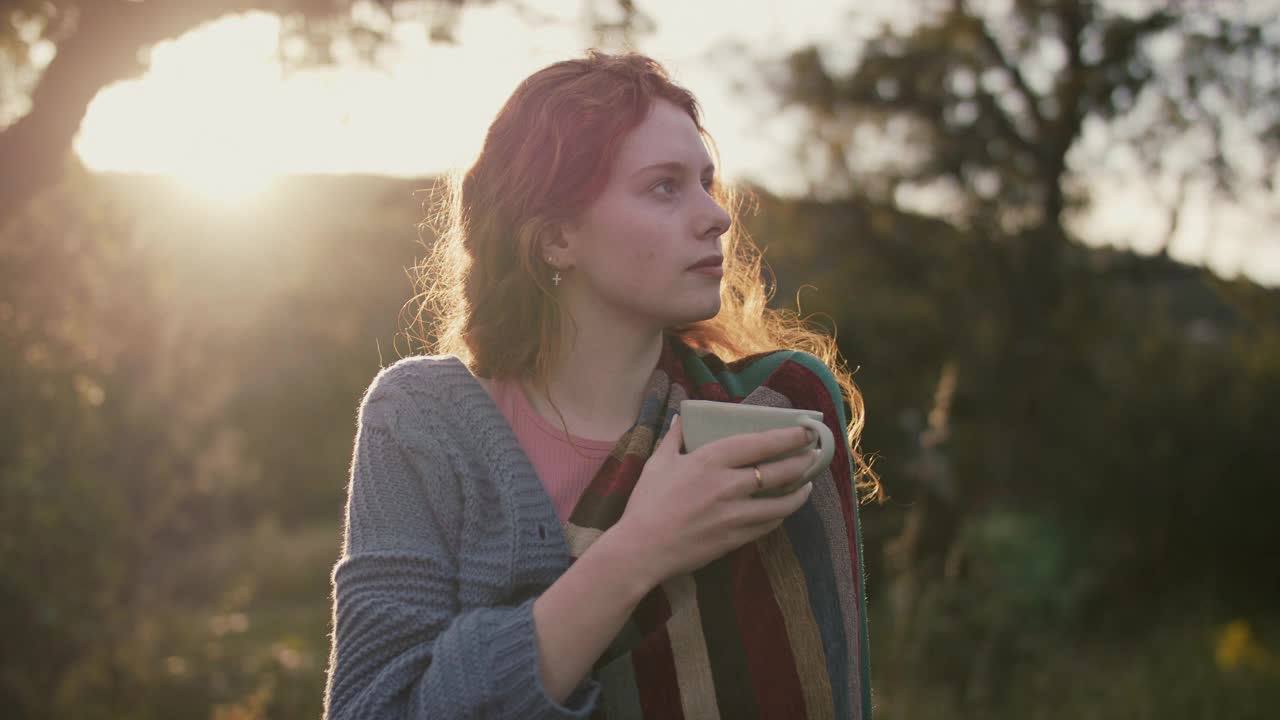 在花园里拿着毯子和茶杯的女人视频素材