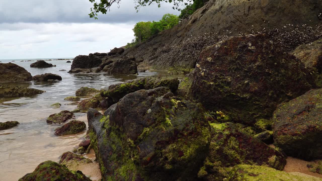 海岸岩石与水晶清澈的水和小波浪。视频素材