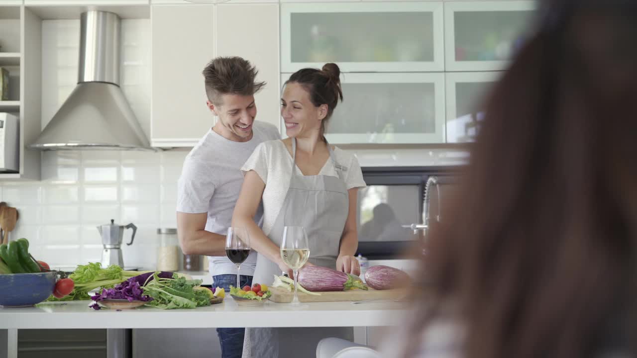 男人在做饭时从背后给妻子系围裙视频素材