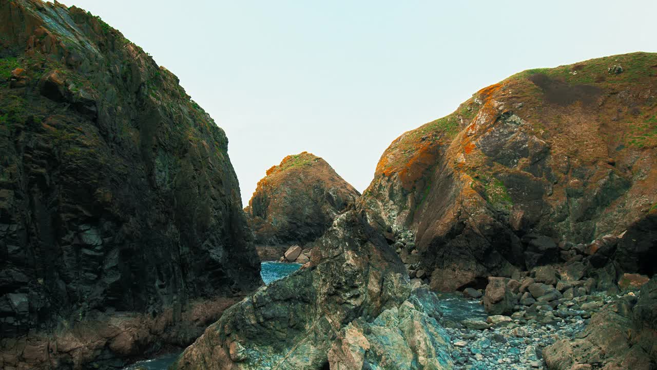 透明的海洋蓝绿色海浪冲击海岸岩石悬崖在4K。视频素材