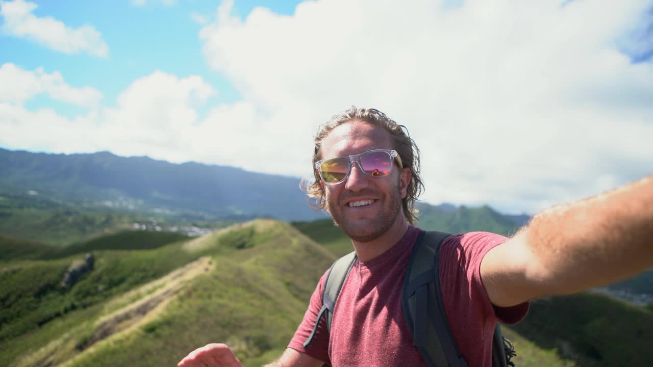 一名在夏威夷徒步旅行的年轻人在山顶自拍。视频素材