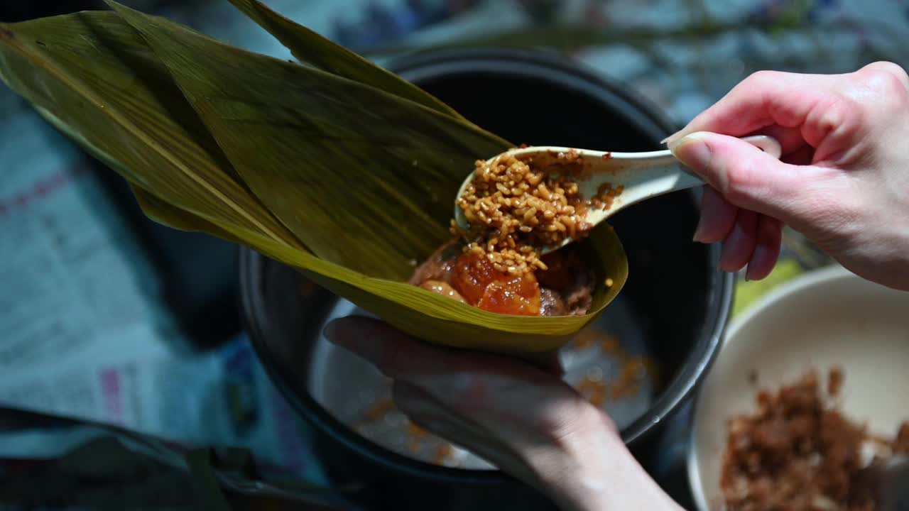 女人用手包粽子。端午节的传统食品视频下载