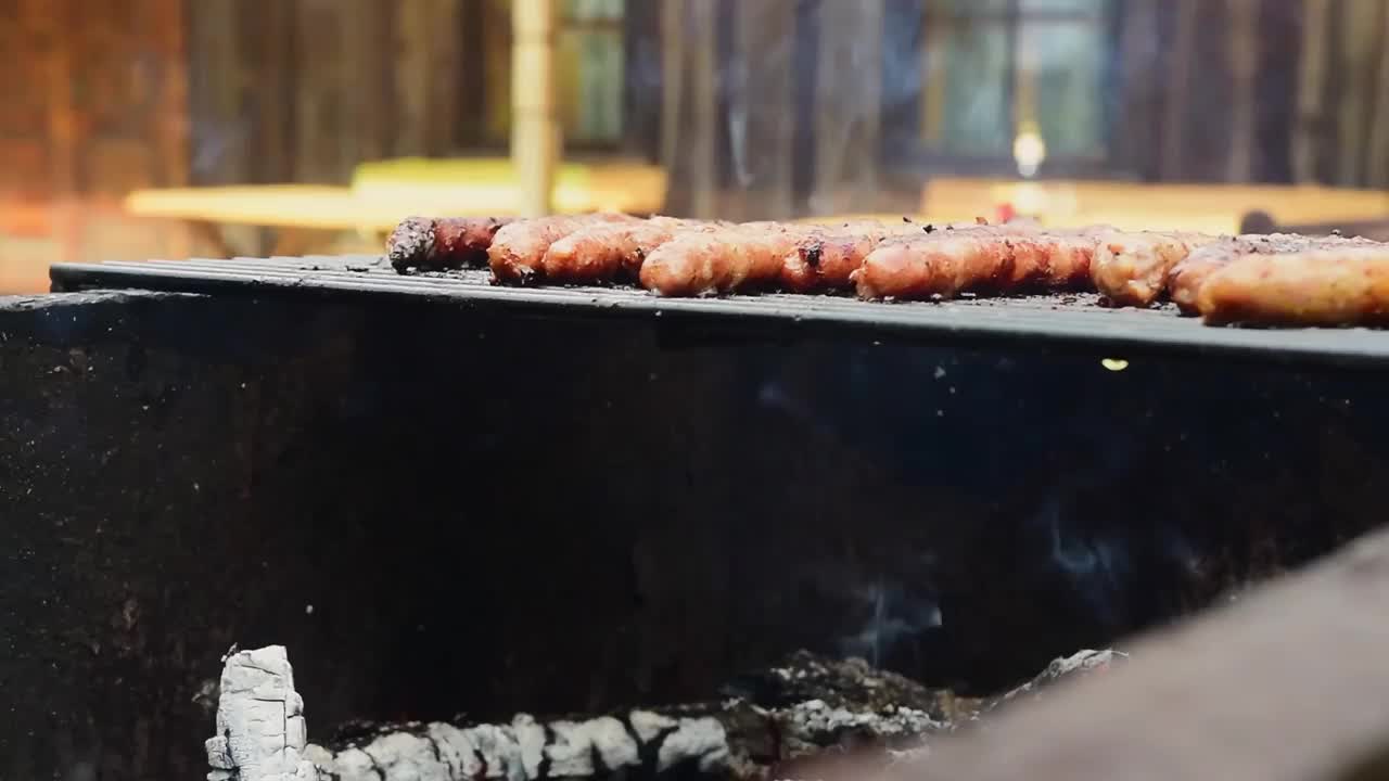 烧烤烧烤不健康的香肠肉经典超市香肠餐。热狗在一个户外烧烤木头房子背景。做野餐的概念。视频素材