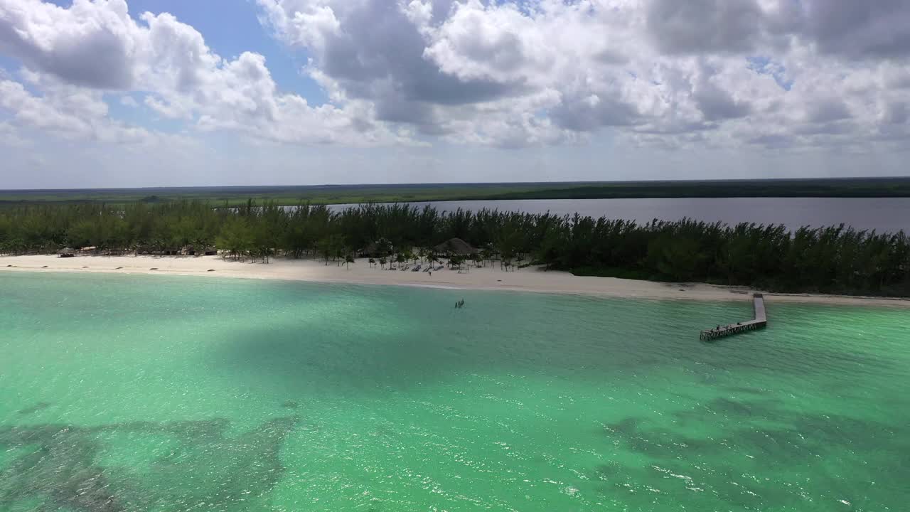 航拍向前美丽的海滩上的甲板椅子，无人机在多云的天空下飞过海洋-科苏梅尔，墨西哥视频素材