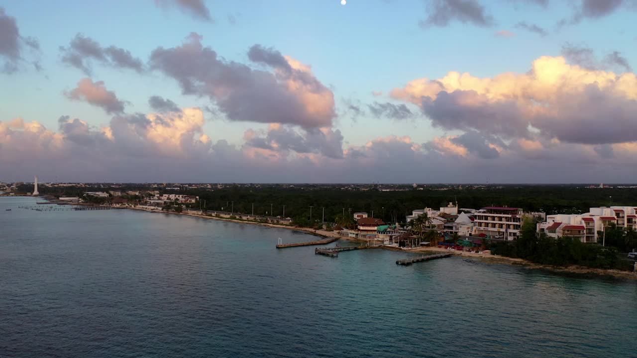 空中平移拍摄的建筑景观对多云的天空，无人机飞过海浪在海上-科苏梅尔，墨西哥视频素材