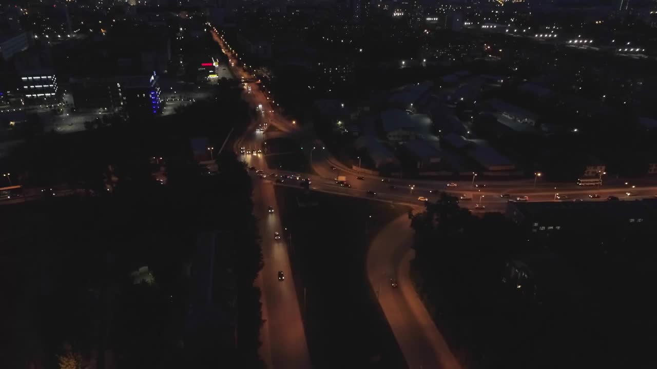 鸟瞰图的城市街道在夜间与环岛公路交汇处视频素材