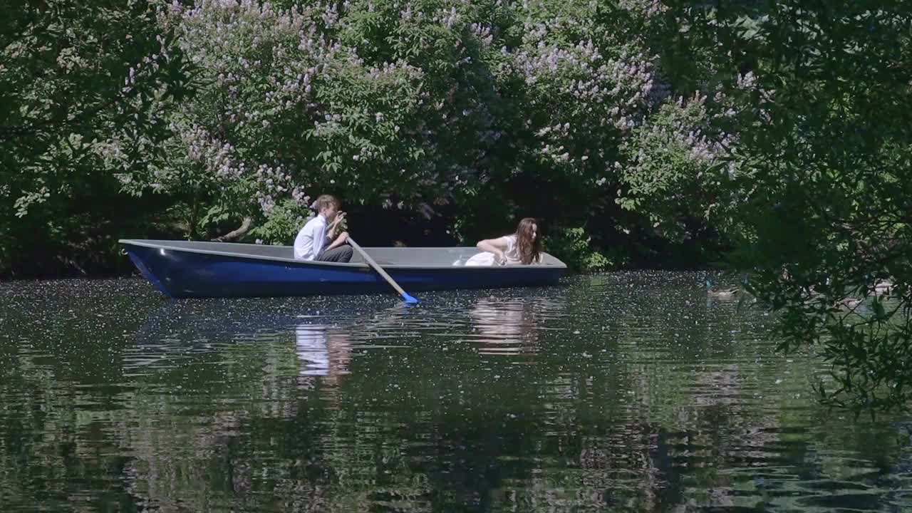 妹妹和弟弟在船上喂鸭子，家人在夏天的湖上度假视频下载