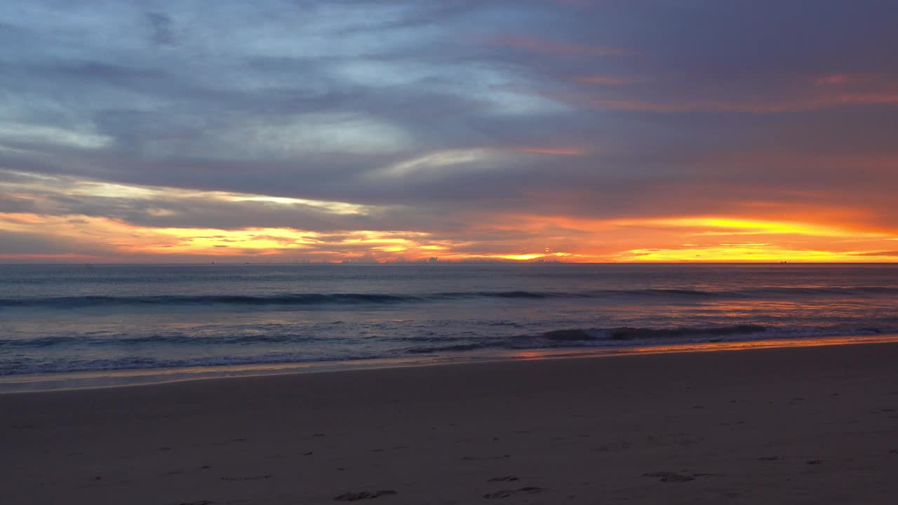 风景、海滩、自然美景和奇观。在一个美丽的日子里，天空是金黄色的，海浪冲刷着美丽柔软的沙滩视频素材