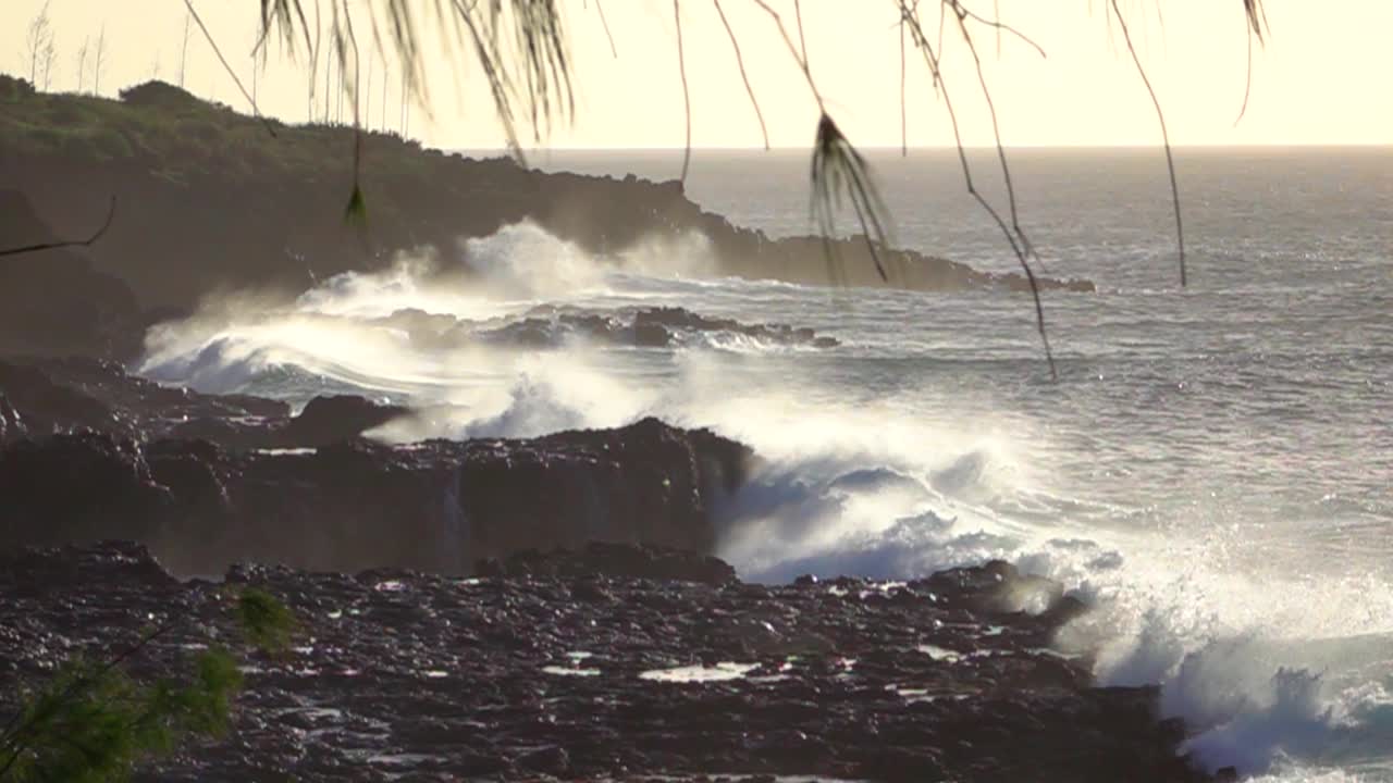 慢动作:日落时海浪撞击火山海岸的电影镜头。视频素材