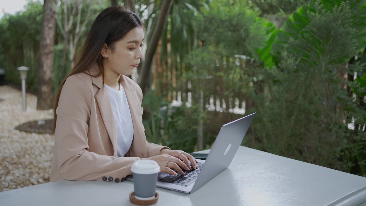 亚洲女商人在咖啡馆用笔记本电脑和智能手机工作。视频素材