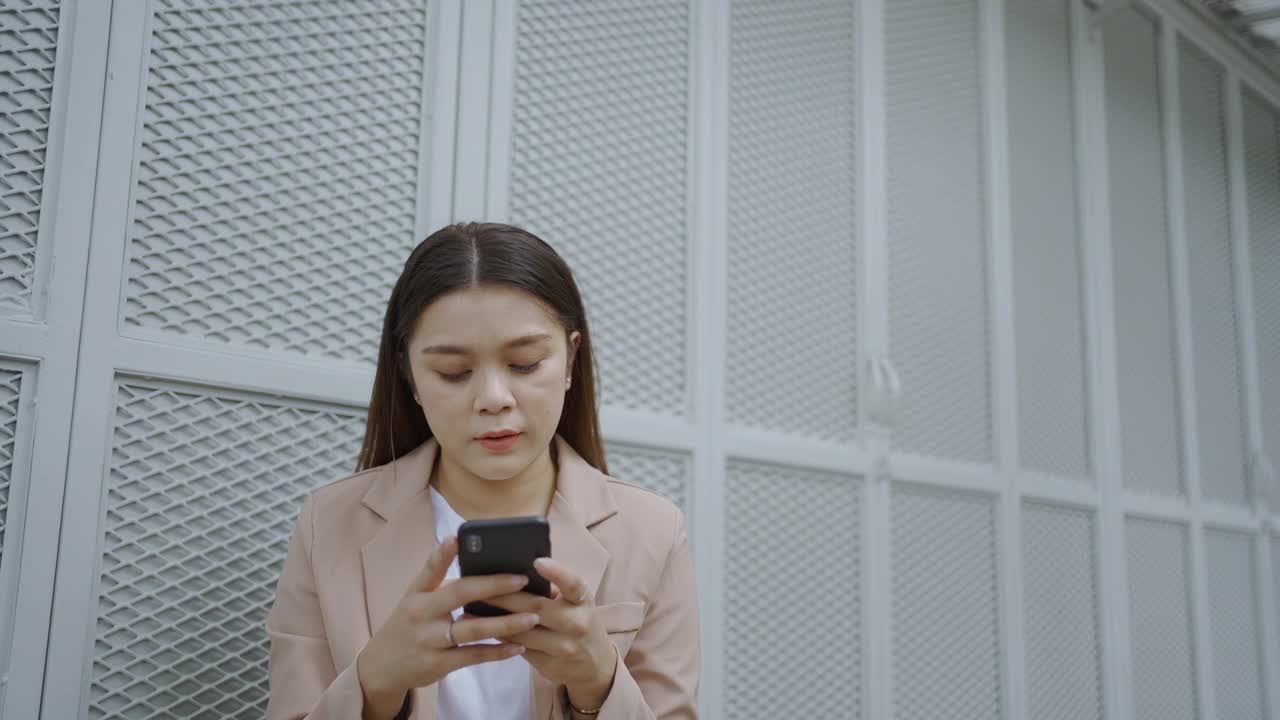 美丽的亚洲女商人使用她的手机。视频素材