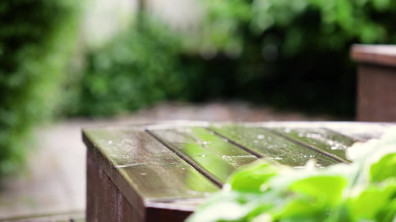 雨落在木楼梯上，雨/水滴在木材上，下雨天的深色橡木上，后院视频下载