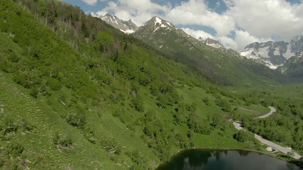 从空中俯瞰峡谷中的高山湖泊。蓝天白云映衬着美丽的山景。山里的娱乐视频下载