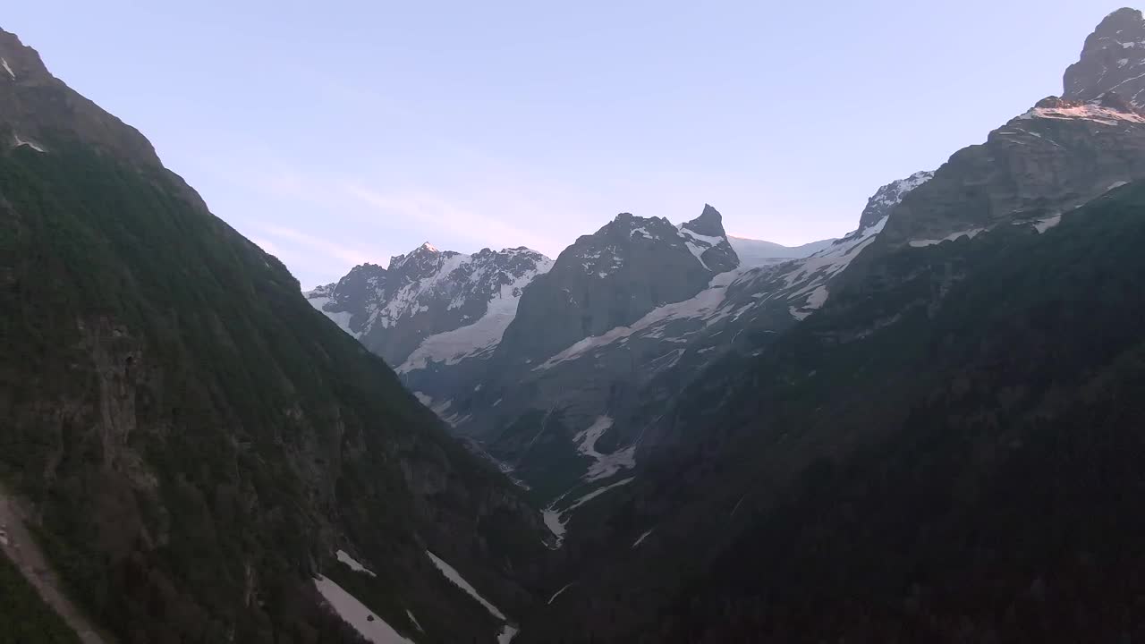 鸟瞰图，延时飞行在山峡。美丽的风景与雪山在绿色森林的背景。在山里旅行视频下载