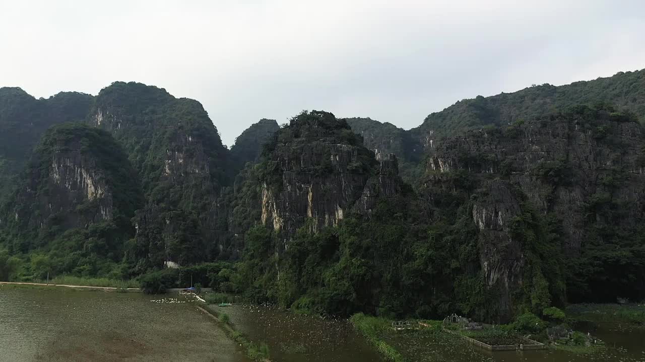 喀斯特岩石在越南的水稻田前堆积，在宁平地区，在下龙湾土地，由无人机。视频素材