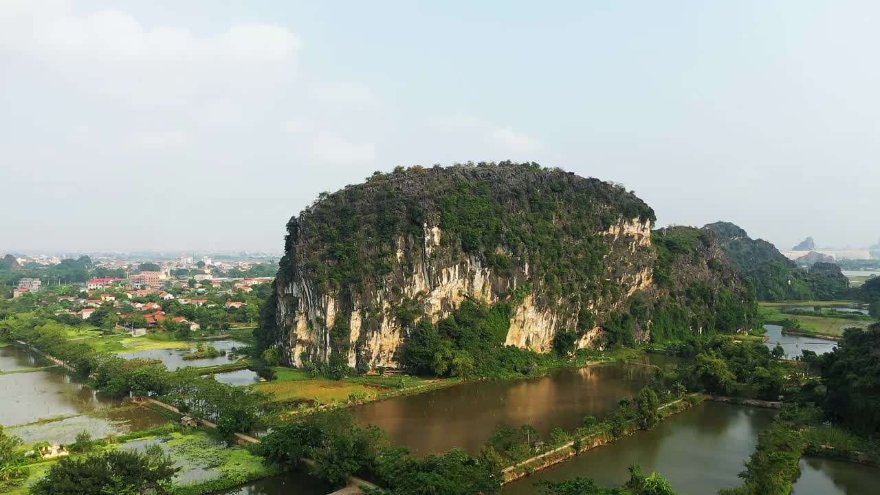 一个传统村庄隐藏在喀斯特峰后，在越南的宁平地区，下龙湾土地，由无人机。视频素材