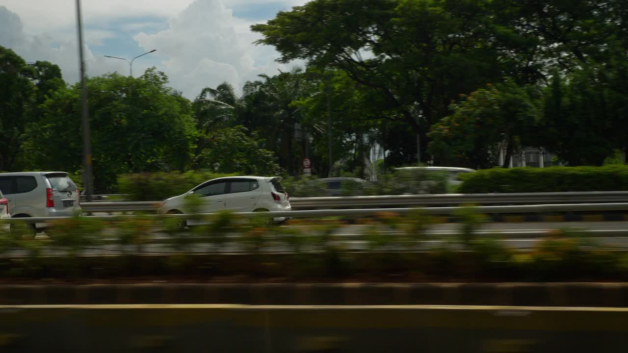 阳光明媚的一天时间雅加达城市汽车乘客侧pov公路旅行全景4k印度尼西亚视频素材