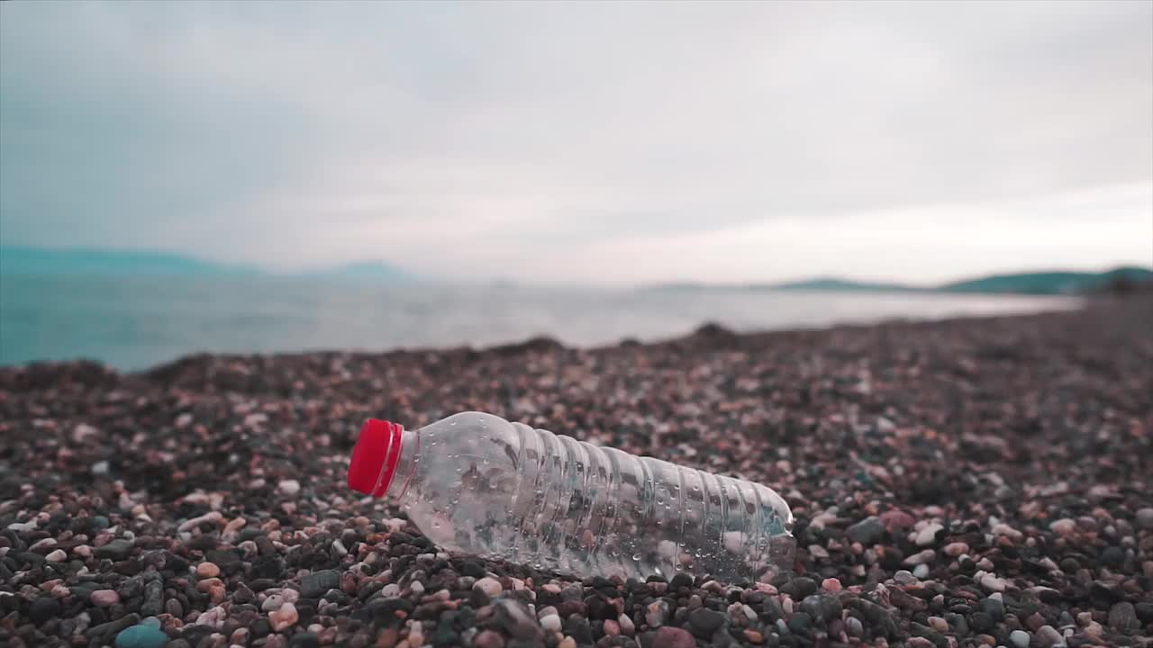 在海滩上收集垃圾、塑料瓶。志愿者为全球变暖，生态工作。视频素材