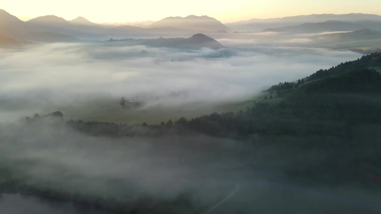 日出时，无人机在波兰Pieniny山脉的Dunajec河上空的云雾中飞行视频下载