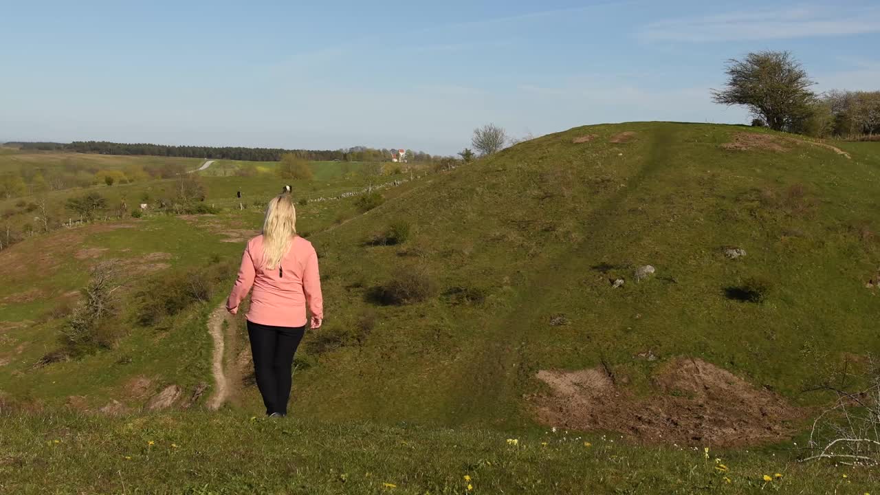 在瑞典Skåne，一个女人在徒步旅行途中穿过令人惊叹的风景视频素材