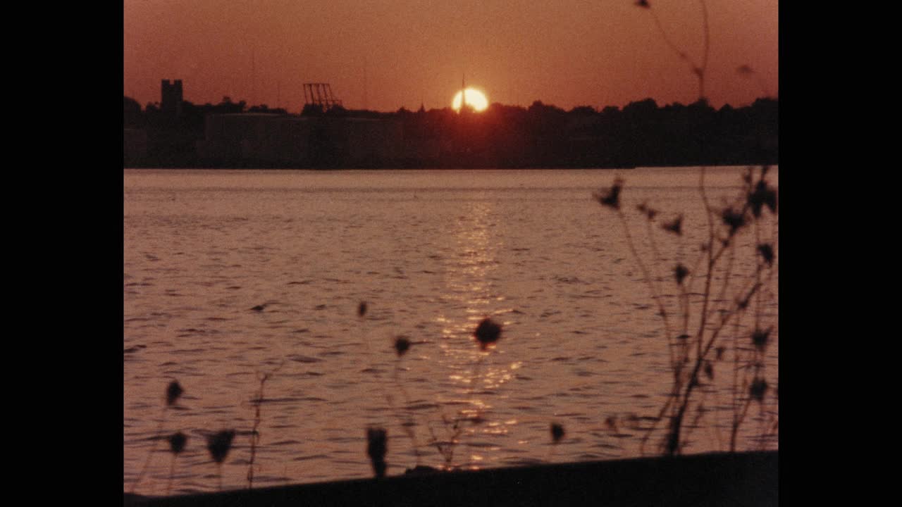 1984年的今天，美国罗德岛，日落时拍摄的城市景色，前景中有一条河视频素材