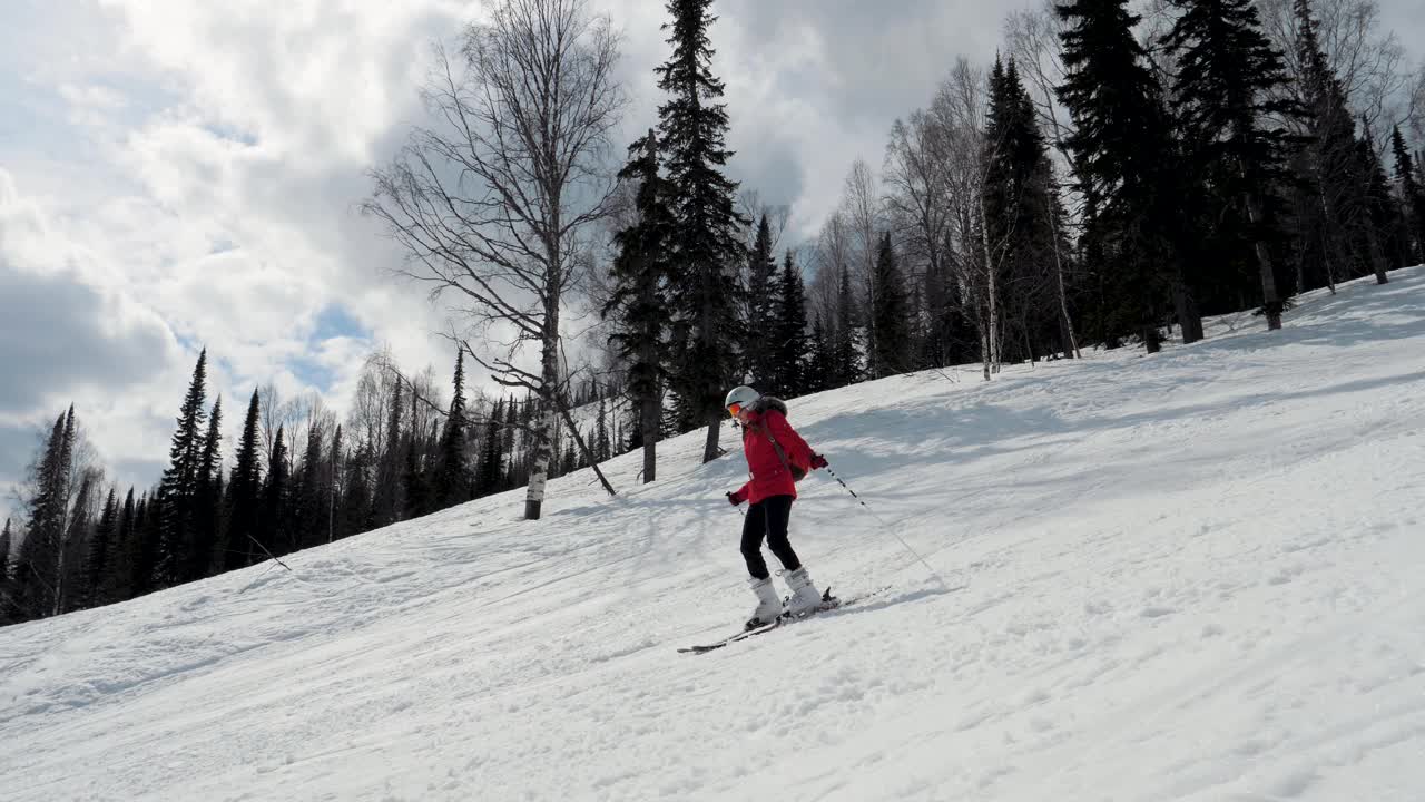 女滑雪者在冬季阳光明媚的一天在山上滑雪坡上滑雪视频素材