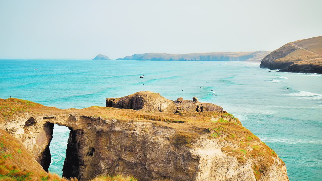 美丽的4K观菲斯特拉海滩，纽基，康沃尔，英国，英国。在晴朗的日子里，人们在凯尔特的蓝色海浪上冲浪。视频素材