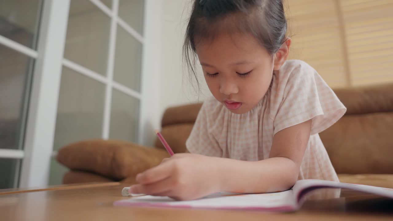 一个亚洲小女孩在家里学习写作业视频素材