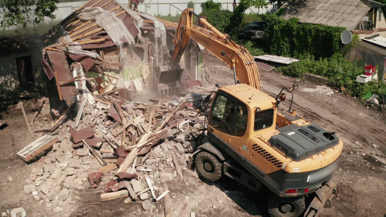 拆除房屋建筑供新建用挖掘机铲斗，鸟瞰图。城市发展视频素材