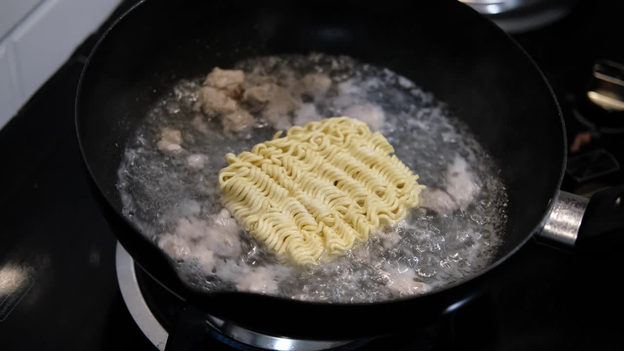 亚洲厨师面条泰国食物在厨房在煤气炉上食物在热水煮沸面条和肉之前服务于幸福的家庭吃视频的慢动作视频素材