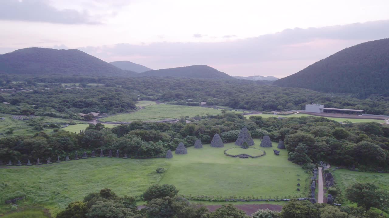 韩国济州岛朝川郡济州石公园草地上的石塔日落景色视频素材