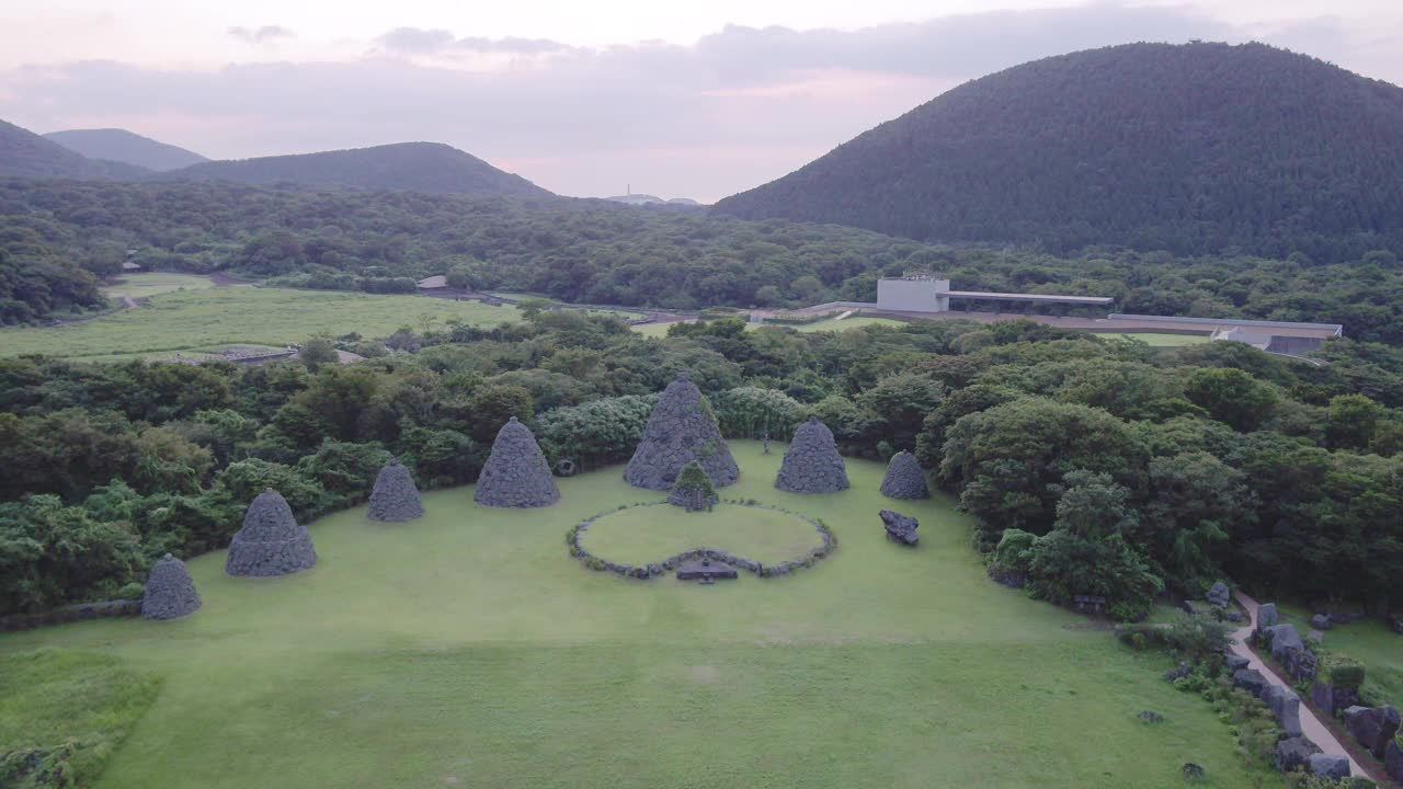 韩国济州岛朝川郡济州石公园草地上的石塔日落景色视频素材