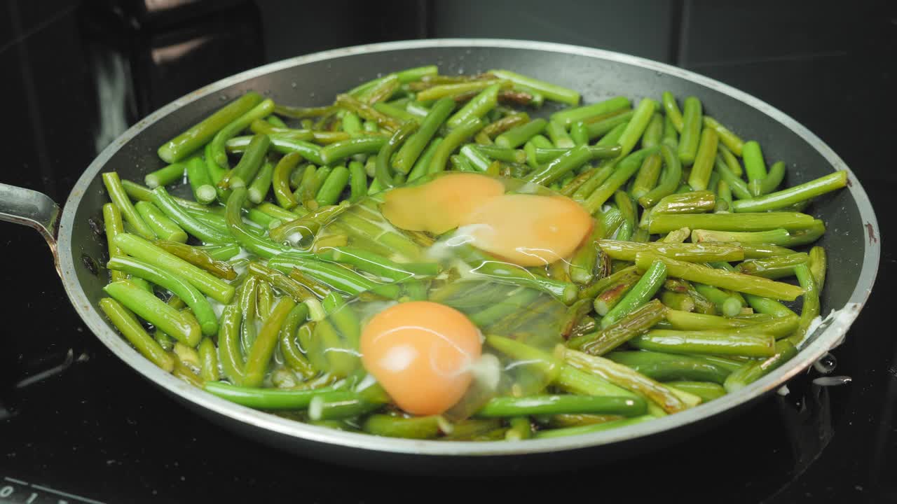 煮青豆和鸡蛋。在家庭厨房里准备健康美味的食物。用炉子上的平底锅煎四季豆和鸡蛋视频素材