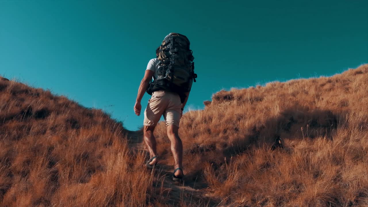 那个背着背包的人正在爬山。慢动作视频素材