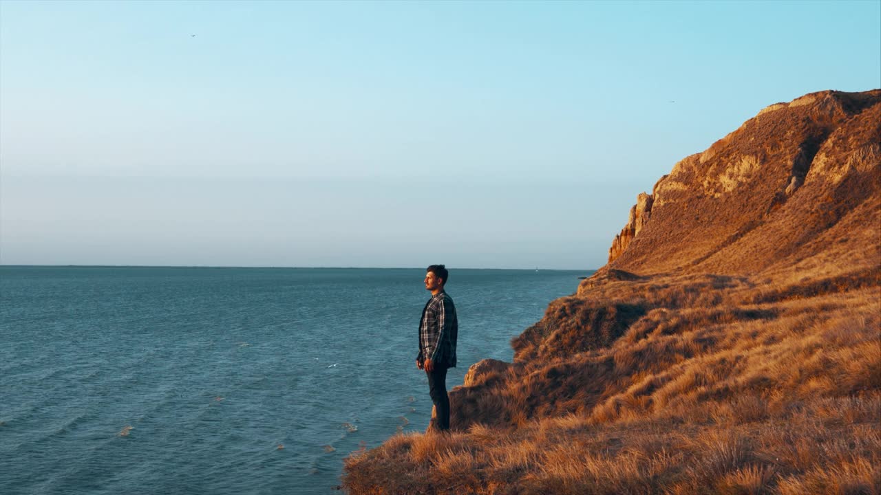 那个站在山边，背对着海景的人视频素材