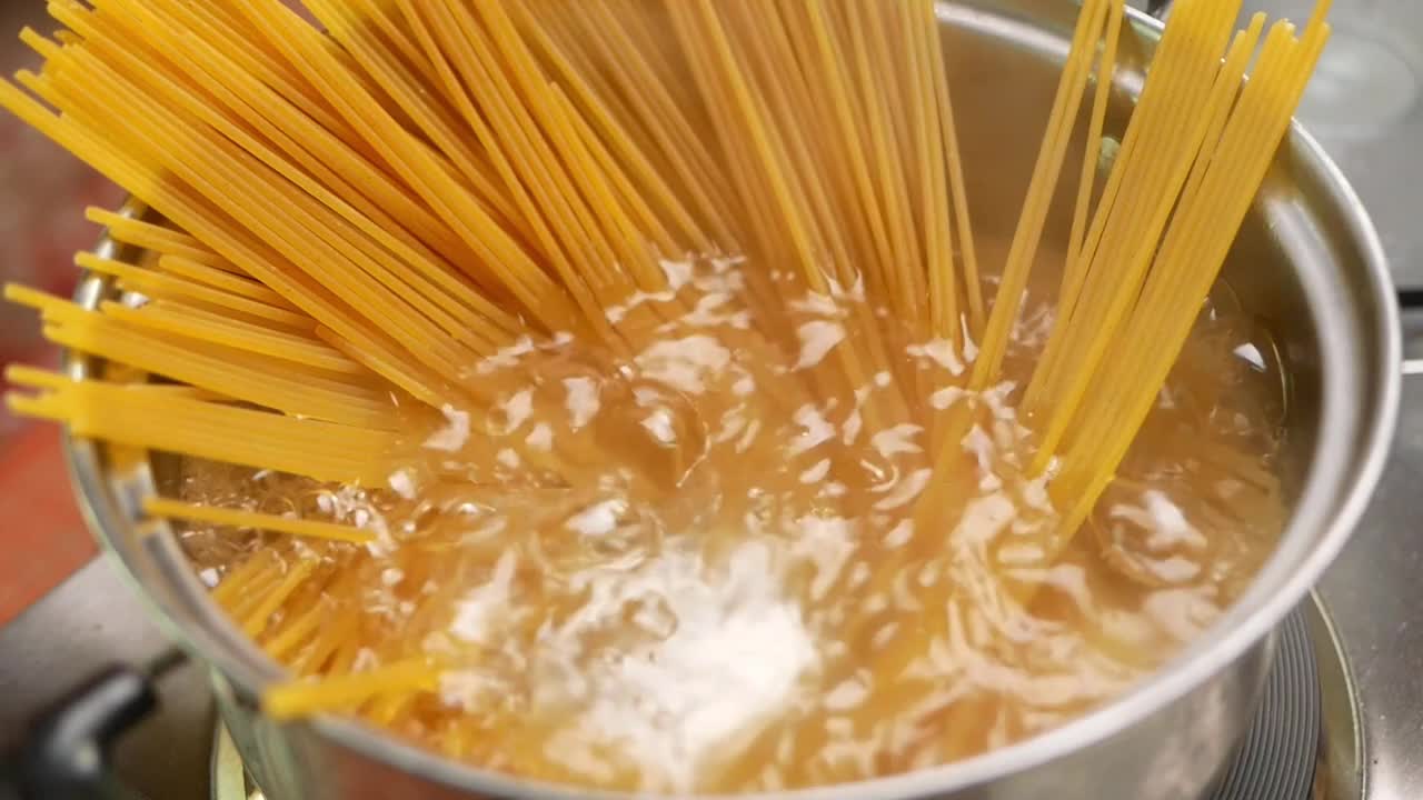 生意大利面正在厨房的锅里用沸水煮熟。健康的意大利食物和烹饪概念。视频素材