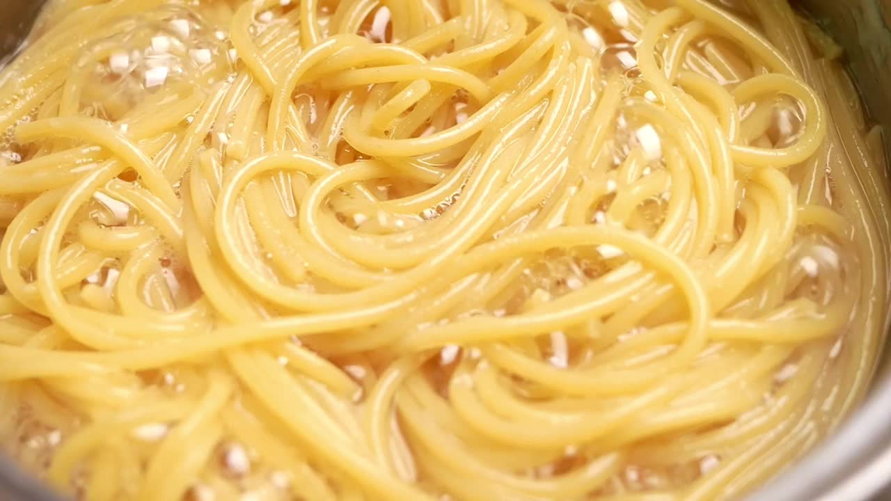生意大利面正在厨房的锅里用沸水煮熟。健康的意大利食物和烹饪概念。视频素材