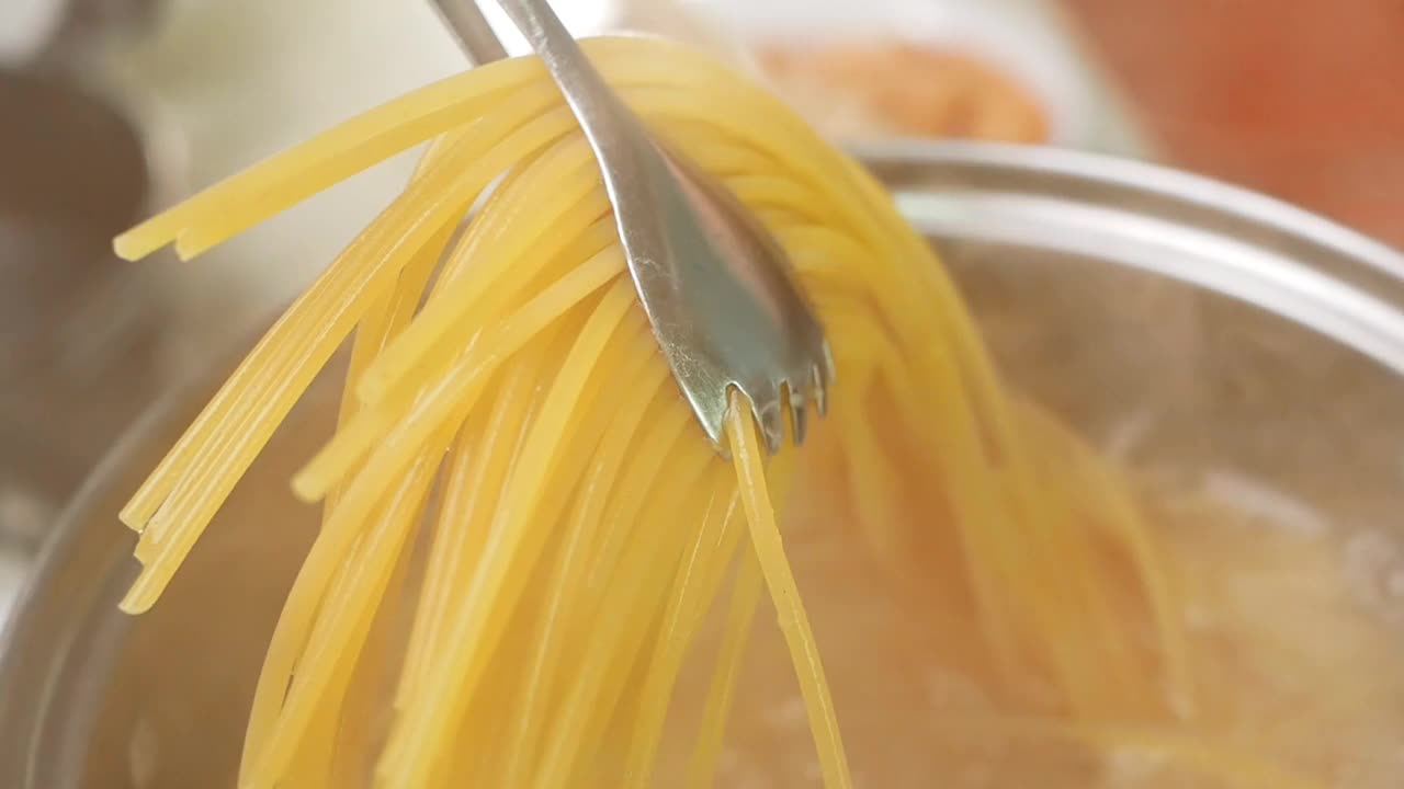 生意大利面在厨房锅里的沸水中煮。健康的意大利食物和烹饪概念。视频素材