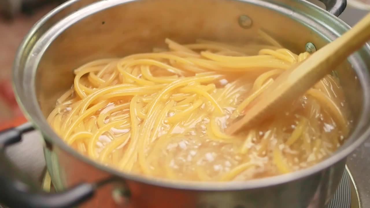 生意大利面在厨房锅里的沸水中煮。健康的意大利食物和烹饪概念。视频素材