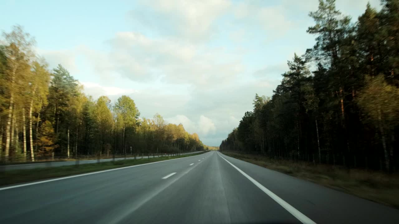 在高速公路上开着车。秋天天气多云，背景视频素材