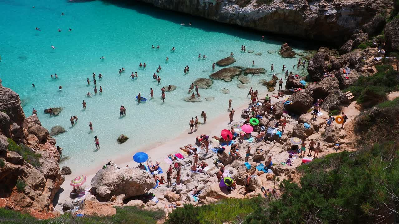 地中海的小海滩，清澈的海水，游客们在这里享受日光浴。马略卡岛的卡拉德尔莫罗。视频素材