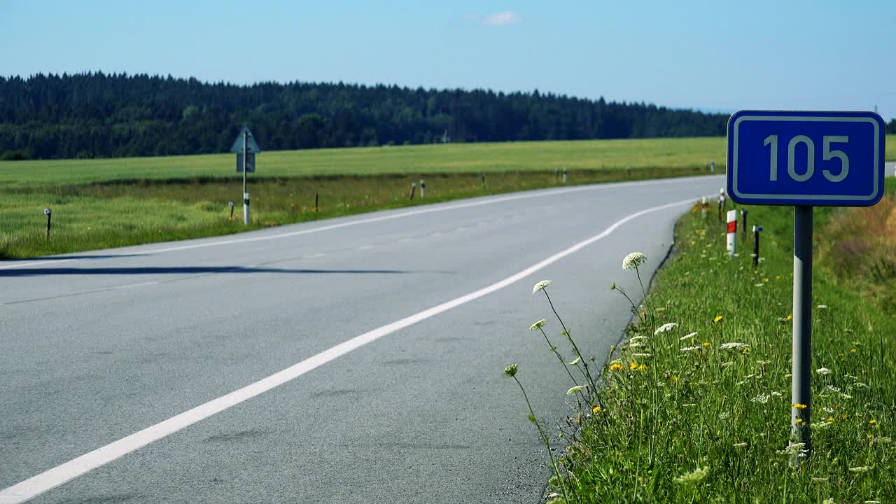 在田野之间的乡村道路-交通标志与道路的数量-晴天视频素材