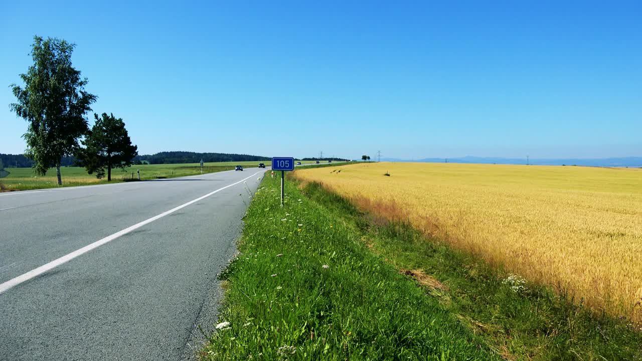 在田野之间的乡村道路-交通标志与道路的数量-晴天视频素材